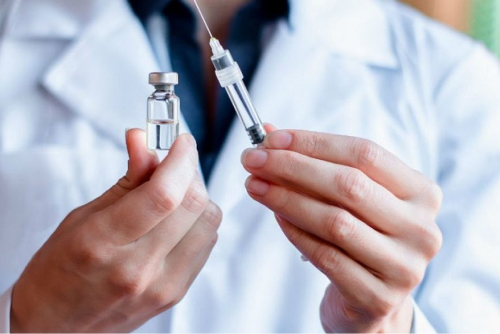 Врач держит шприц